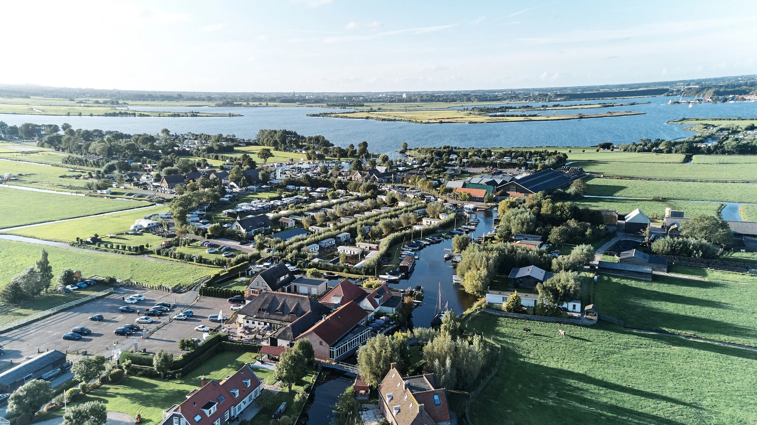 Luchtfoto van Patrick en Lyn's trouwdag bij Meerhoeve in Oud Ade: groene polders, water en landelijk schoon