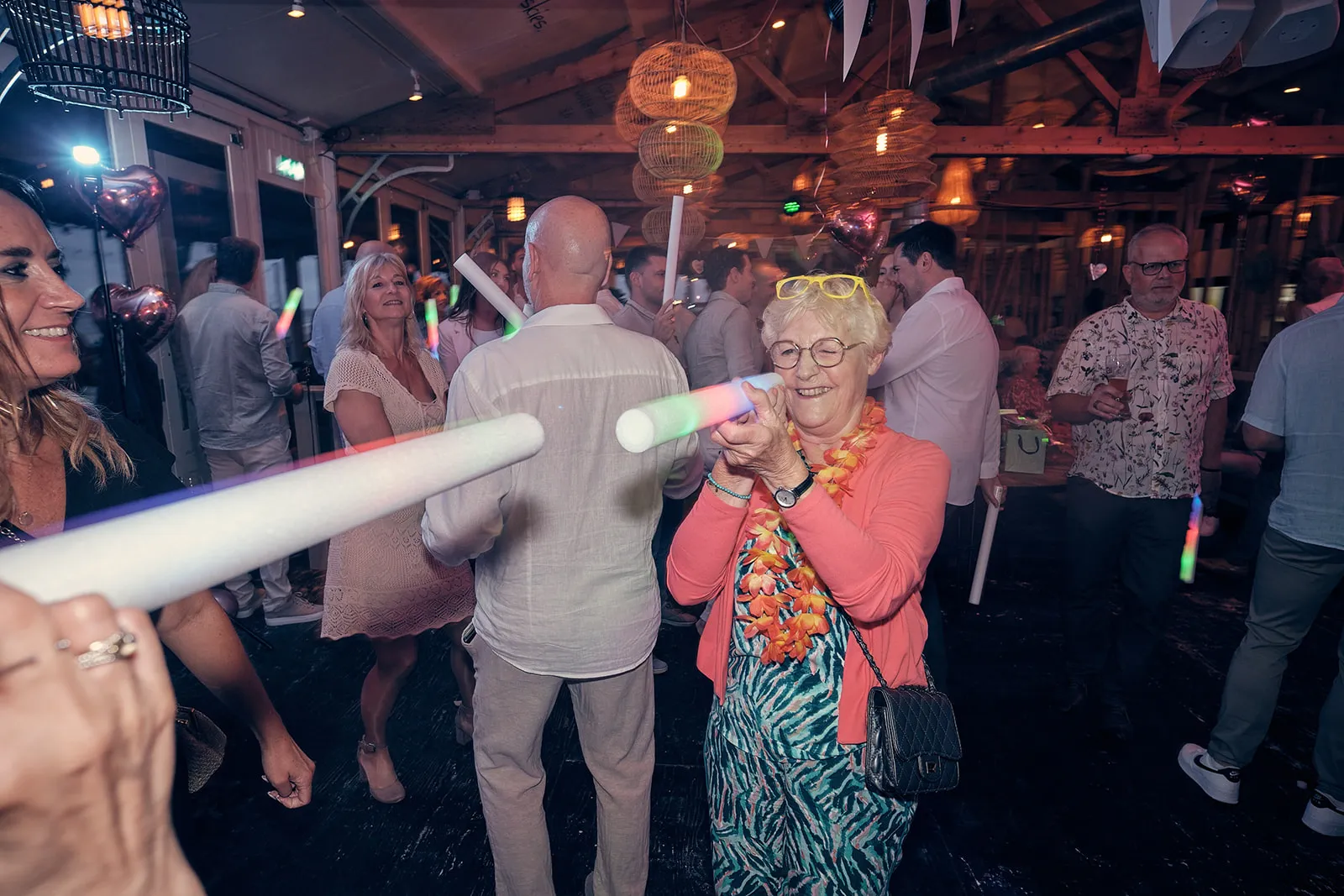 Bruidspaar Silvia en Patrick dansen met gasten op trouwfeest in Beachhouse Kijkduin Den Haag, bruidsfotografie
