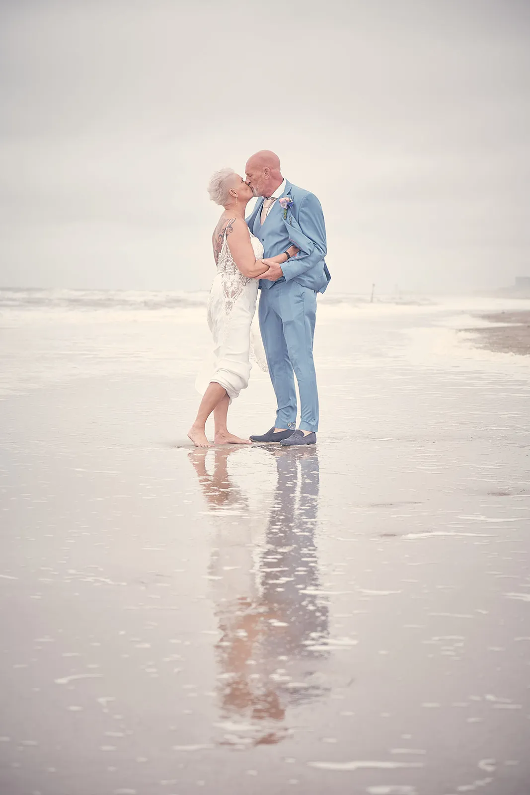 Bruidspaar Silvia en Patrick kust op het strand bij Beachhouse Kijkduin Den Haag, romantische trouwreportage