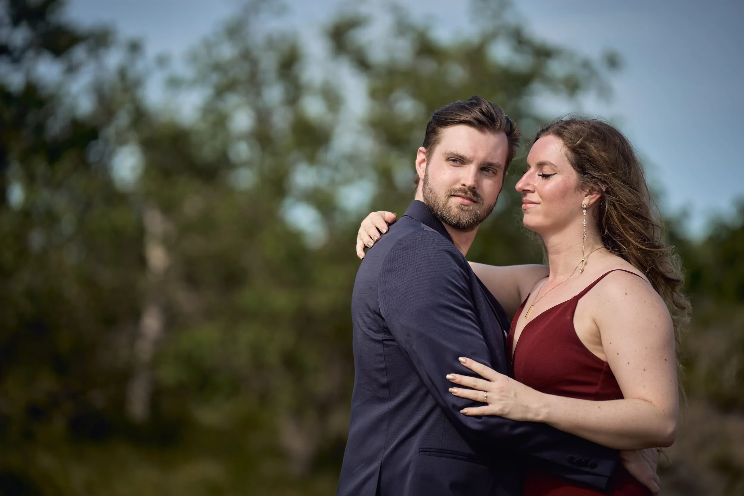 Verliefd stel in natuur, man in donkerblauw pak en vrouw in bordeaux jurk, loveshoot koppelfotografie — Trouwshoot Stefa
