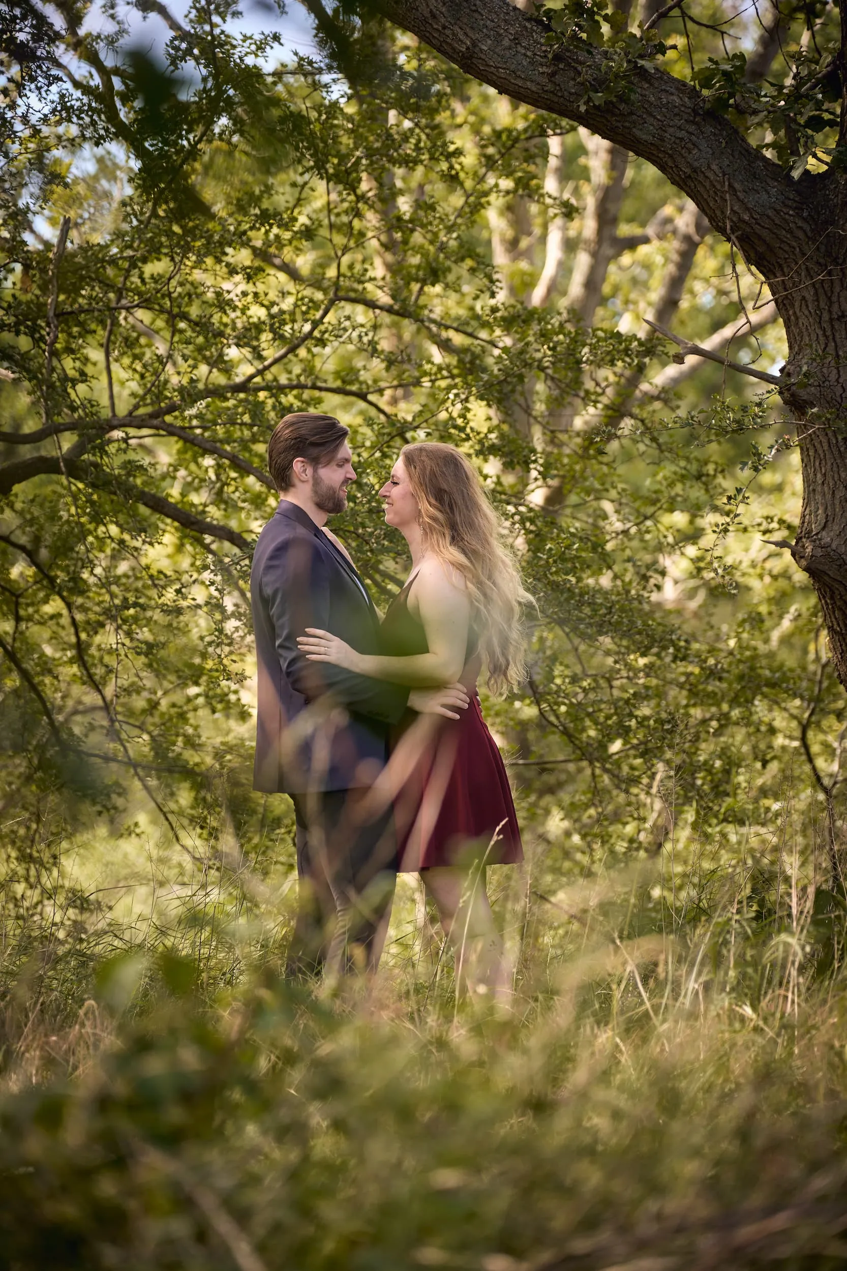 Verliefd koppel omarmt elkaar onder oude boom in groen landschap, romantische loveshoot — Trouwshoot Stefan Segers