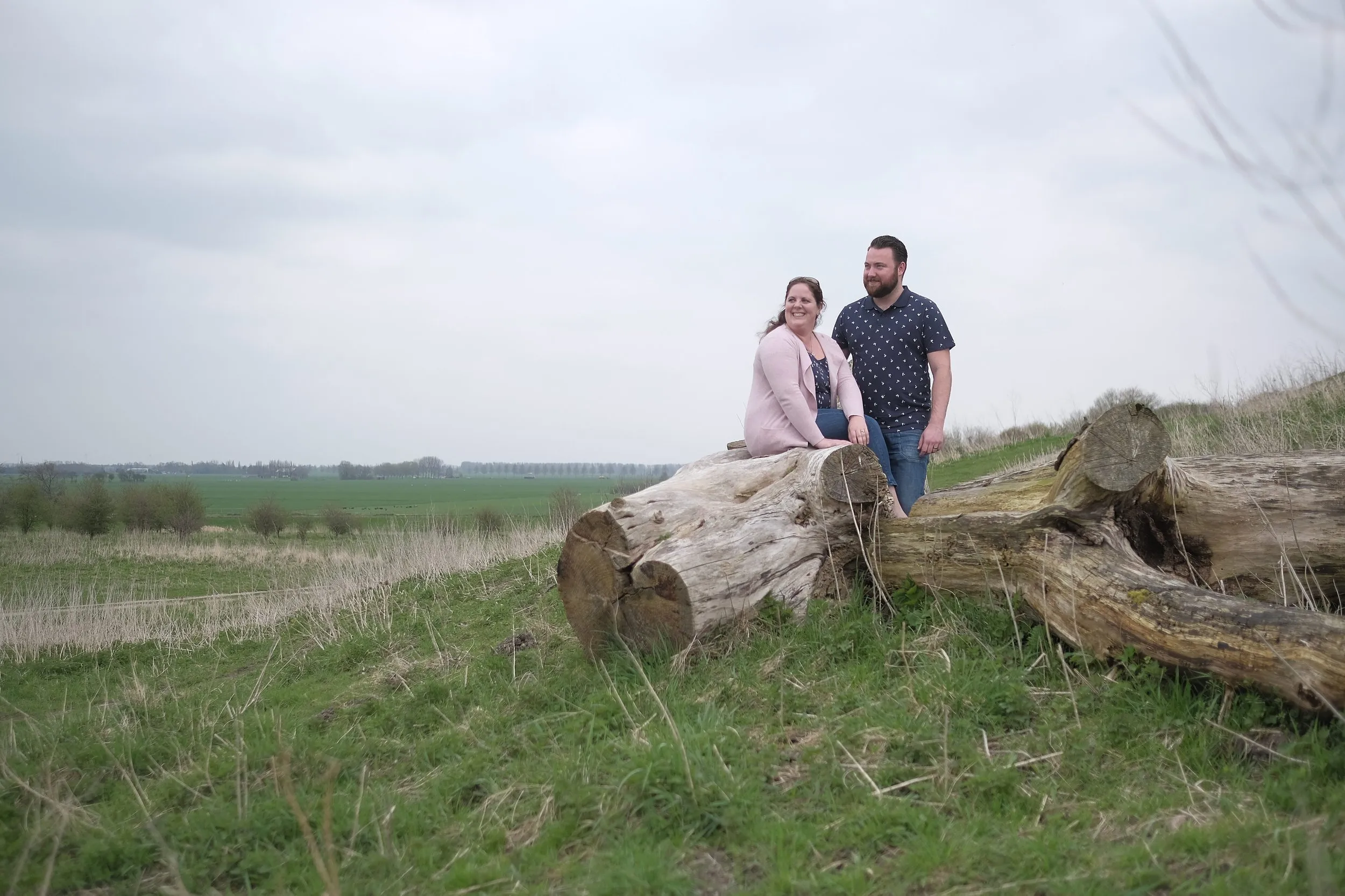 Koppel zit op omgevallen boom in natuurgebied Zoetermeer, loveshoot koppelfotografie — Trouwshoot Stefan Segers