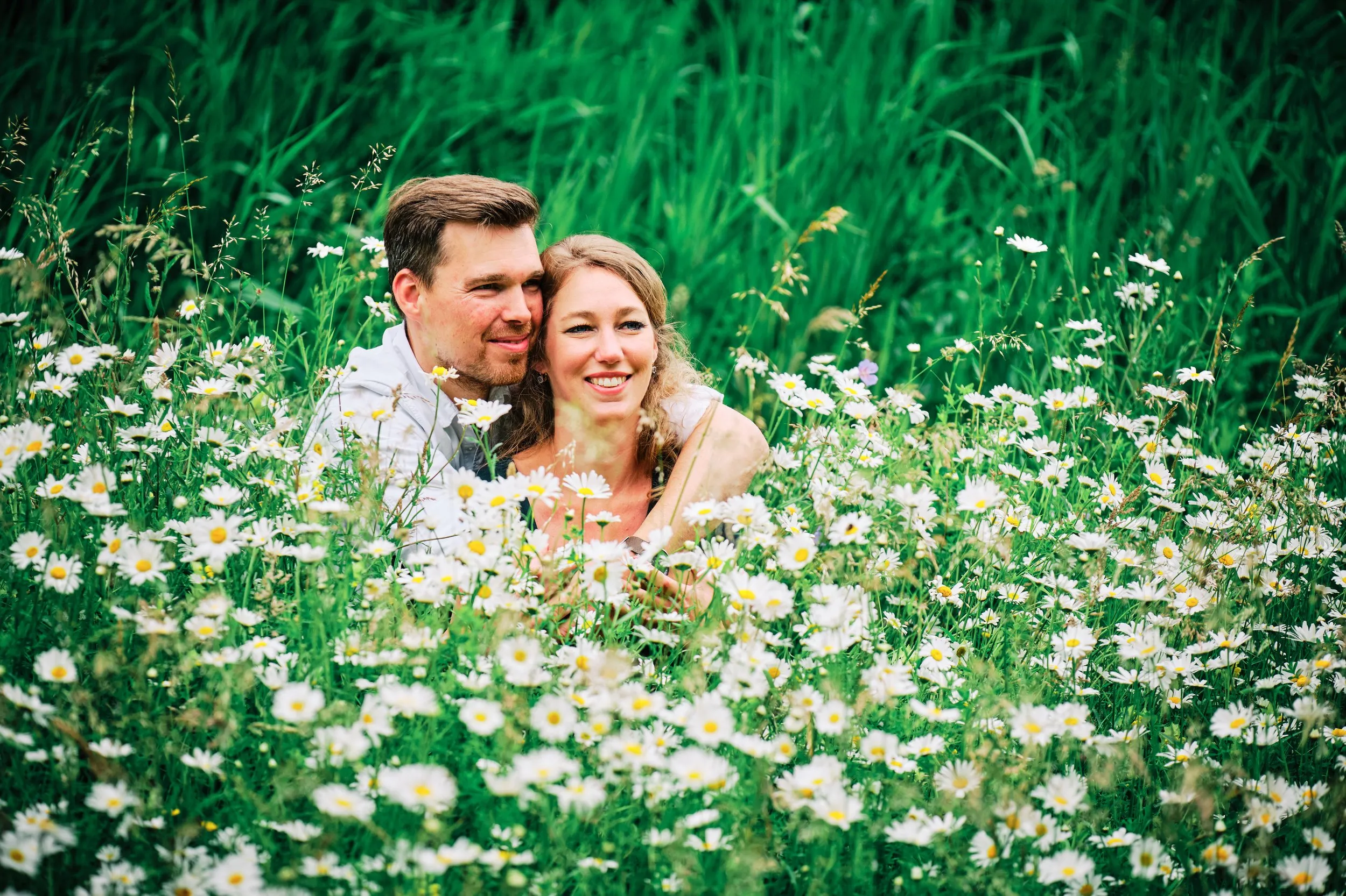 Verliefd koppel knuffelt in bloeiend madeliefveld in Zoetermeer, loveshoot fotografie — Trouwshoot Stefan Segers