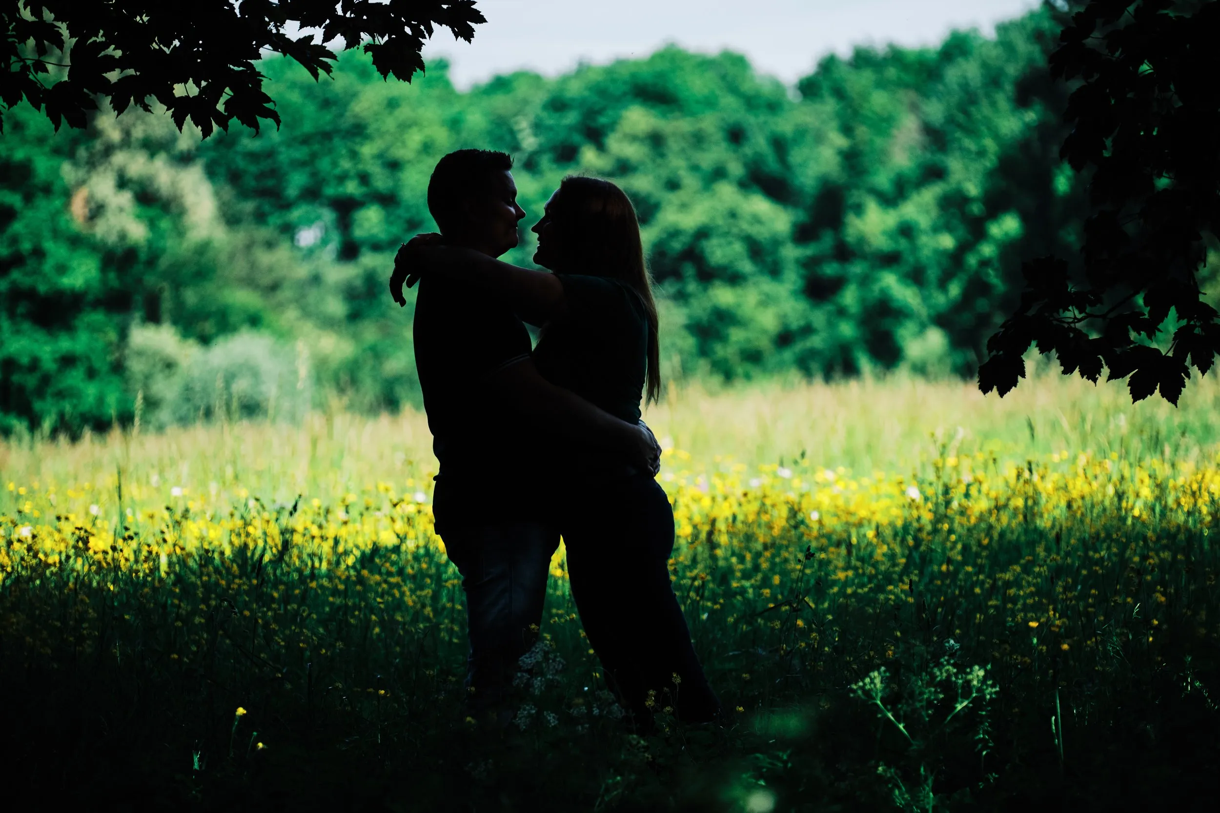 Koppel omarmt elkaar in geel bloemen veld Zoetermeer, romantische loveshoot — Trouwshoot Stefan Segers