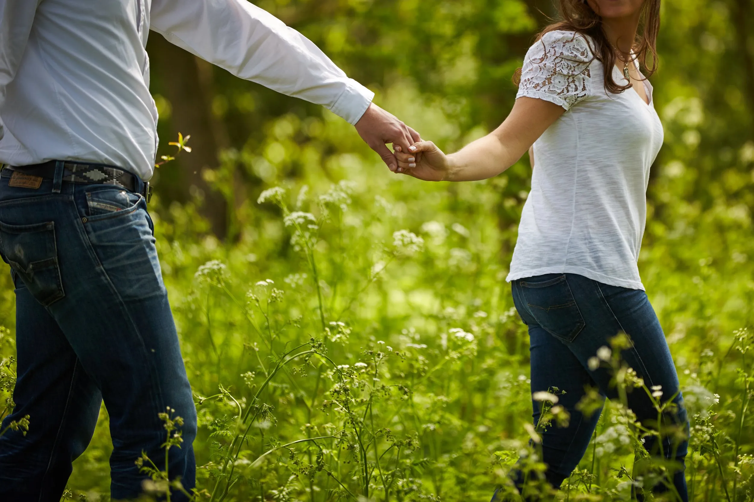 Verliefd stel hand in hand in bloeiend groen veld, loveshoot in Zoetermeer — Trouwshoot Stefan Segers