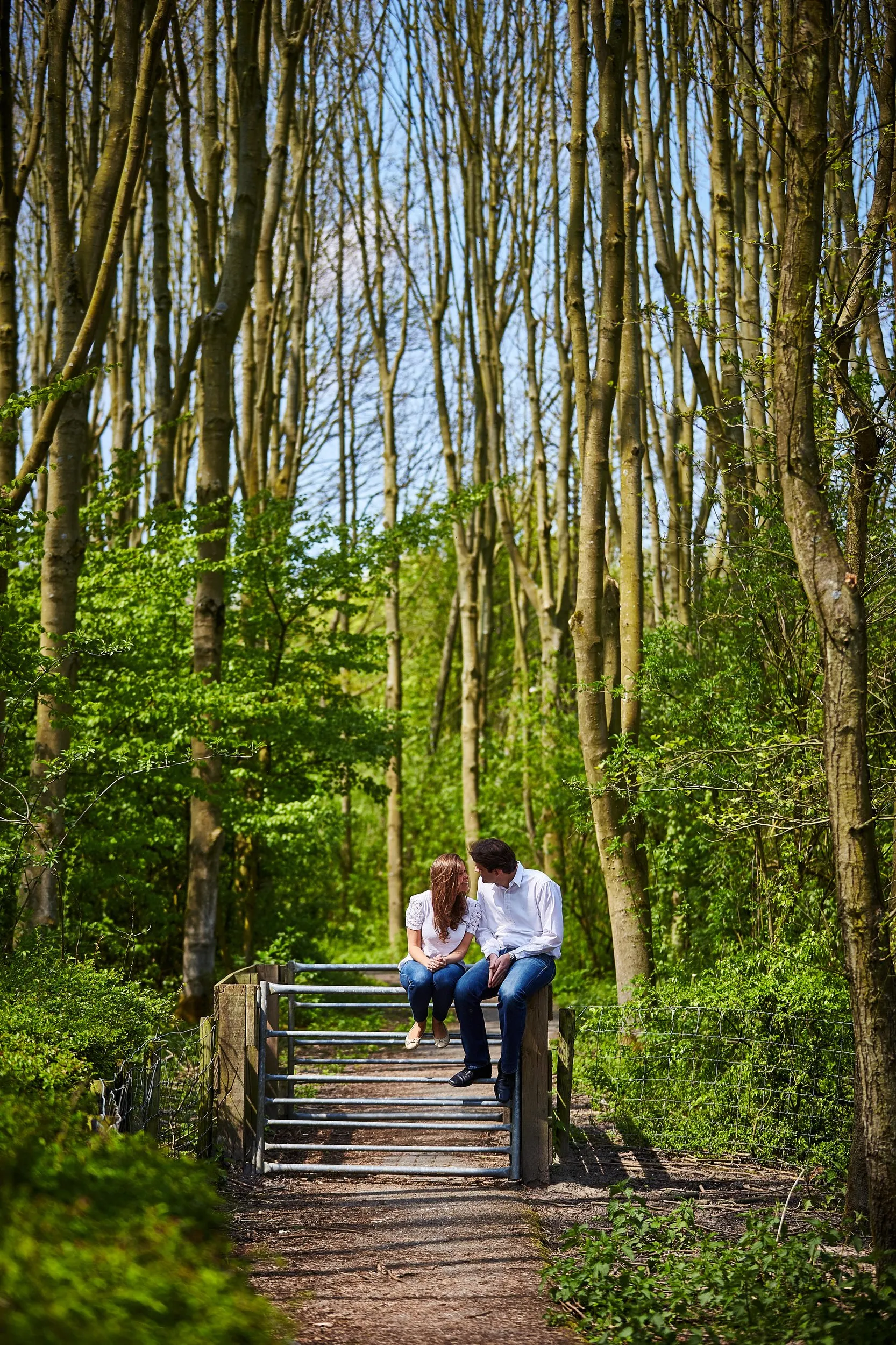 Verliefd koppel zit samen op houten brug in het bos van Zoetermeer, loveshoot — Trouwshoot Stefan Segers