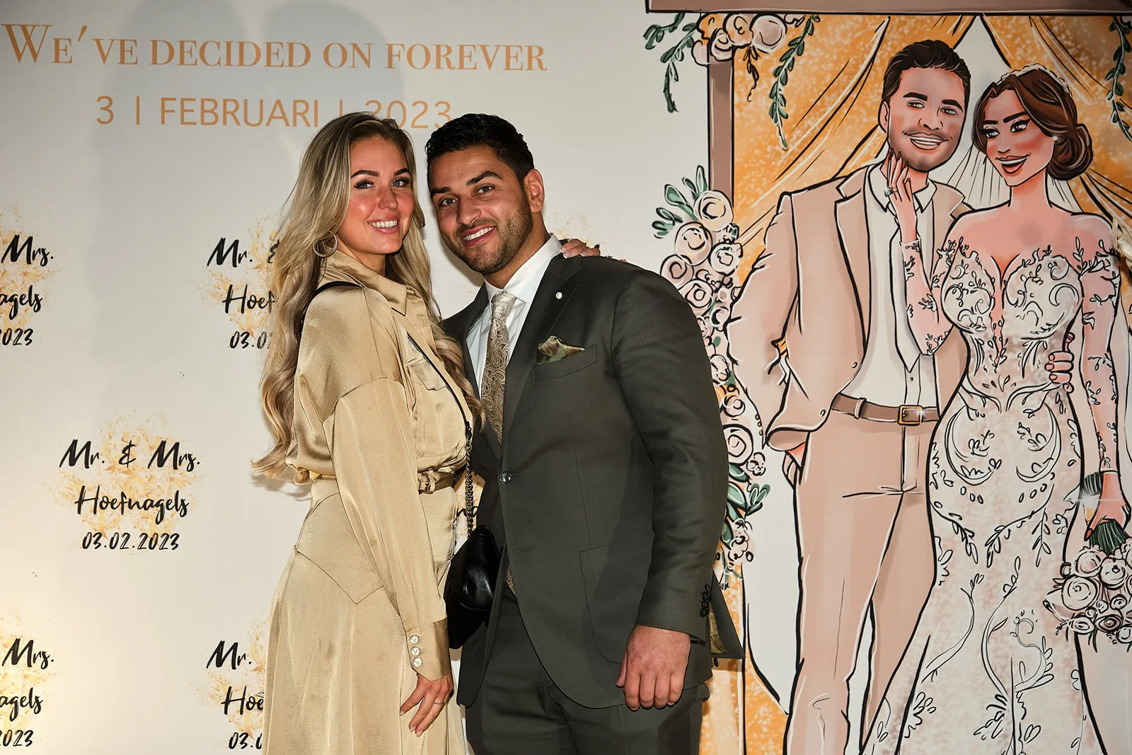 Bruidspaar poseert voor fotobord met illustratie, bruidsfeest huwelijk, elegante party fotografie