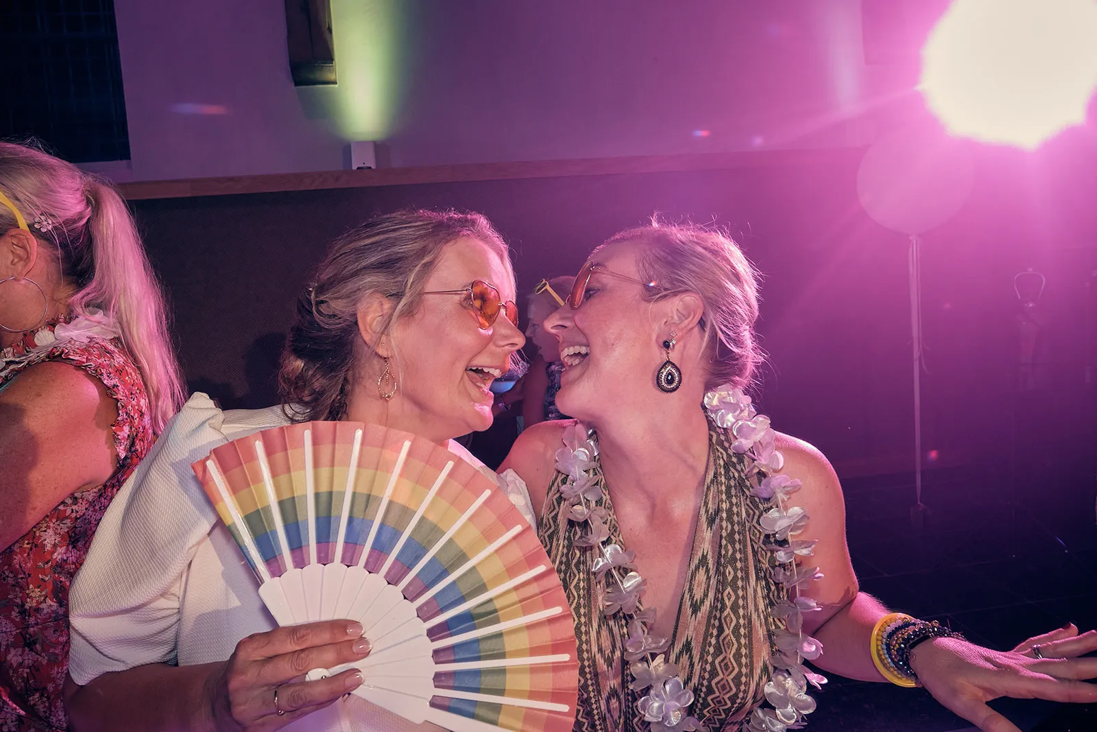 Bruidsgasten feesten uitbundig op trouwfeest Bram en Elles, regenboogwaaier en roze discolicht, Het Dikke Torentje - Trouwsho