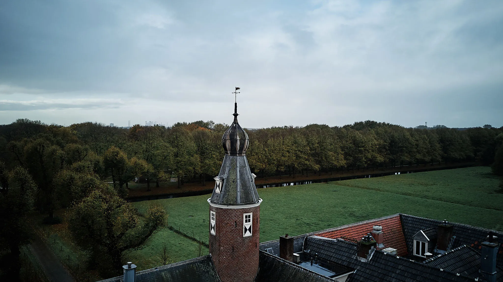Karakteristieke Nederlandse landschapsfoto met historische toren en weiden onder bewolkte hemel