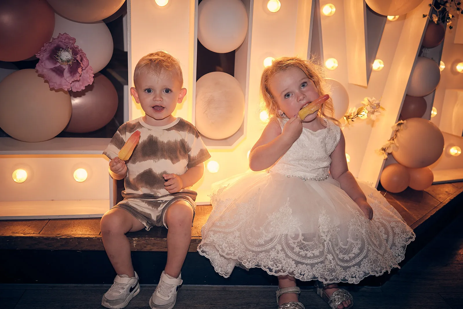 Kinderen Jacky en Jordy spelen in verlichte fotohoek bruiloft Wantij Paviljoen Dortrecht, trouwreportage
