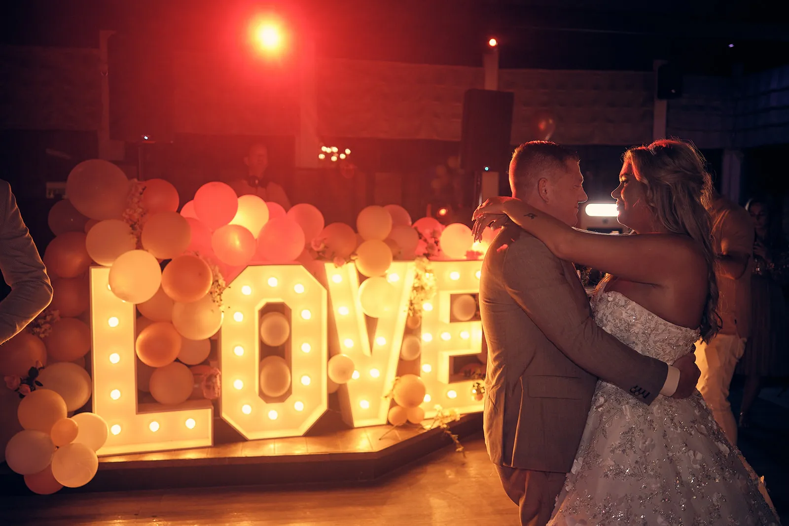 Bruidspaar Jacky en Jordy danst bij verlicht LOVE-bordje, avondreportage Wantij Paviljoen Dortrecht