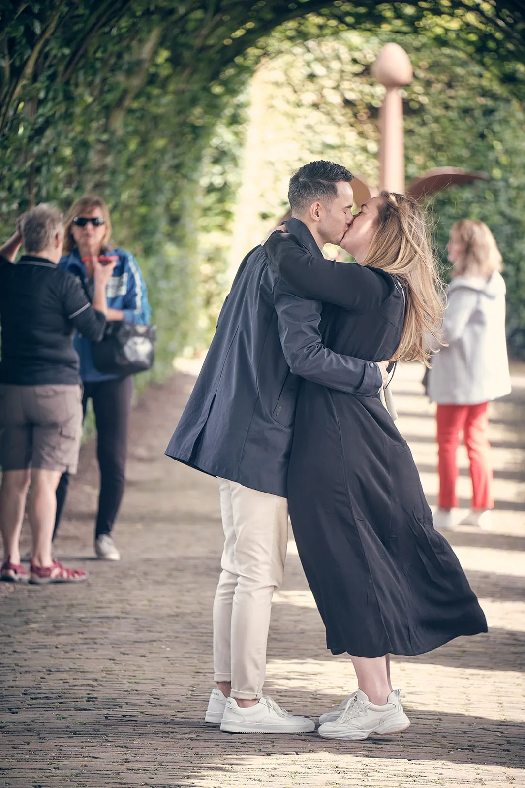 Wai Ho en Marinka kussen romantisch onder de groene bomengang bij Muiderslot kasteel
