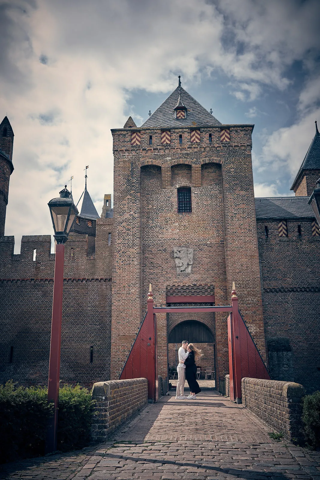 Bruidspaar Marinka en Wai Ho kussen bij poort Muiderslot kasteel, romantische loveshoot trouwreportage