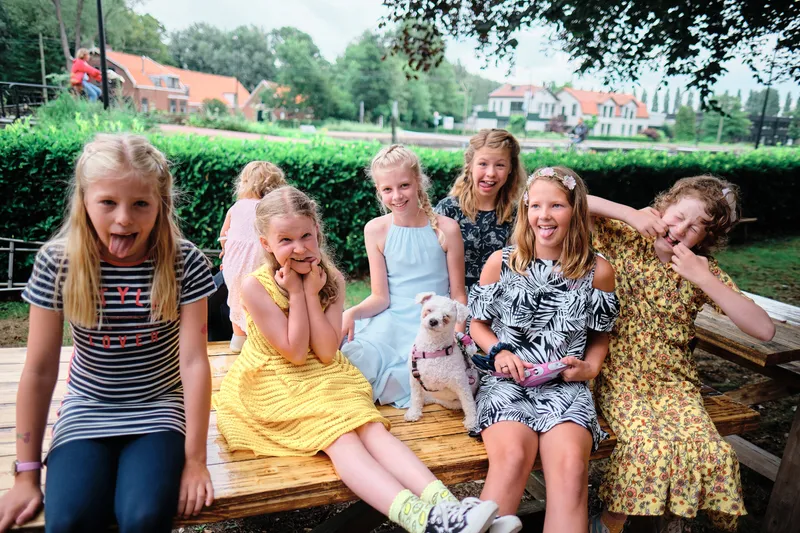 Meisjes lachen op een houten bank in de tuin