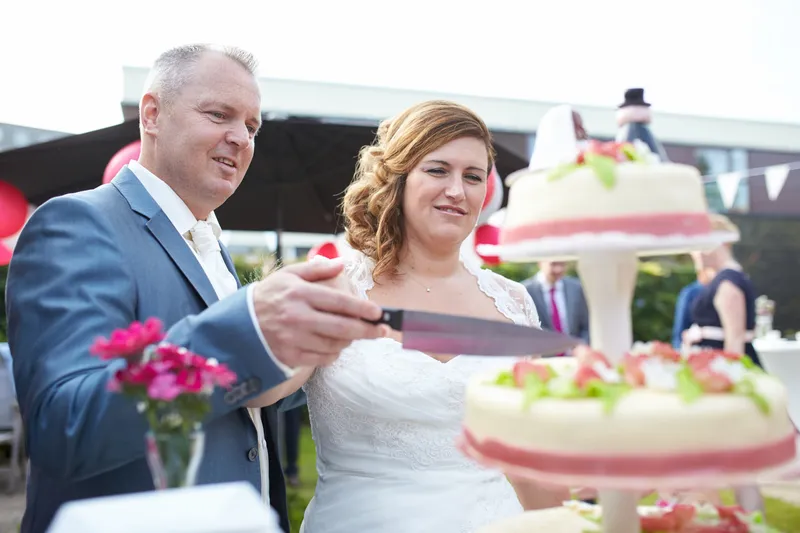 Eric houdt het mes boven de taart, Jessica kijkt blij toe