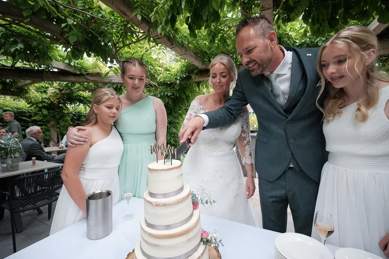 Marleen, Eric en de bruidsmeisjes snijden de taart aan