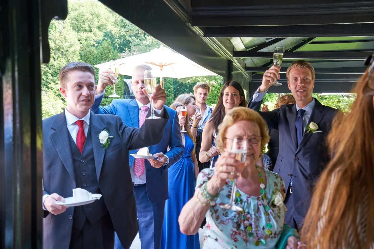 De gasten heffen het glas op Herman en Margherita