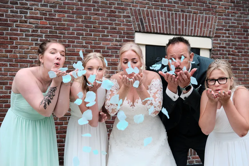 Marleen, Eric en de bruidsmeisjes blazen blauwe confetti