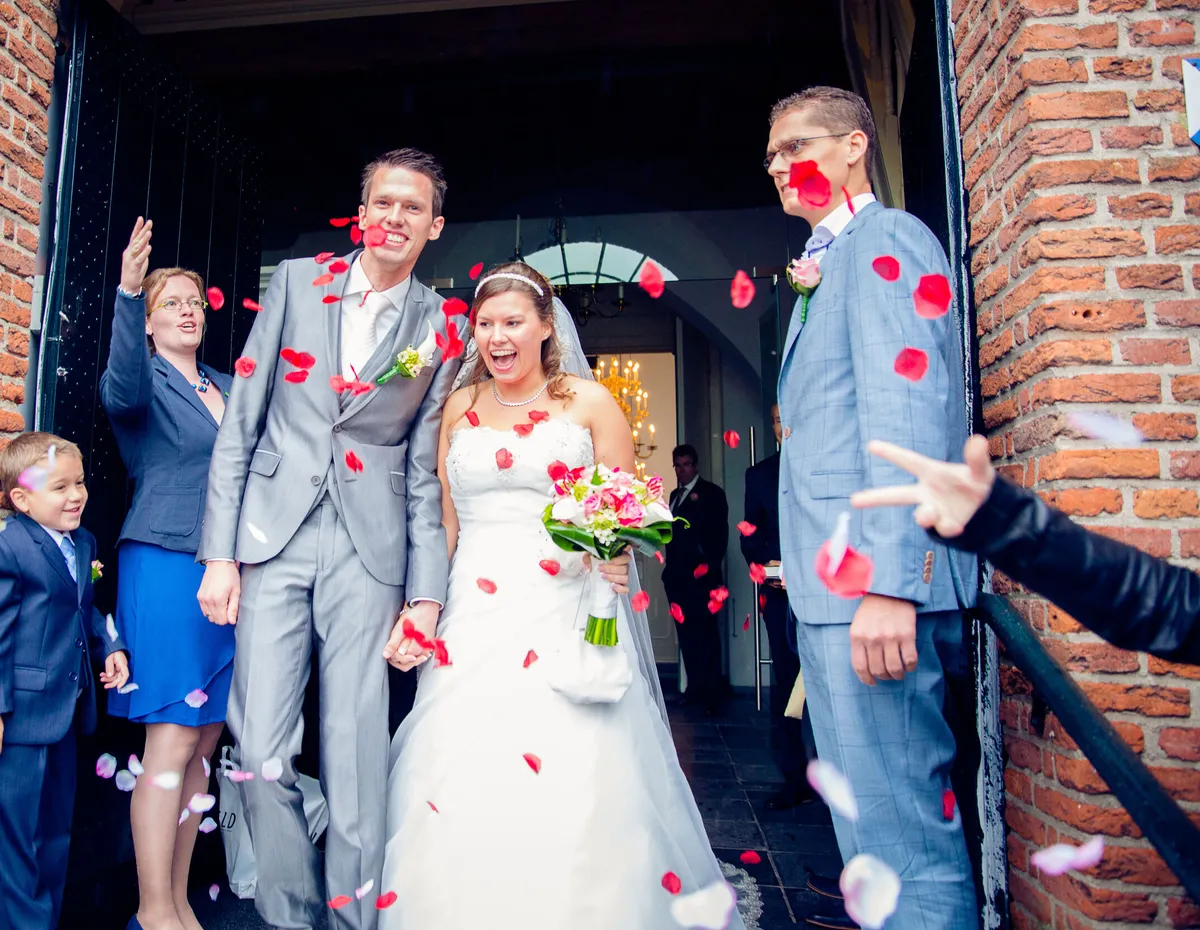 Mark en Annika komen de Oude Kerk uit onder een regen van rozenblaadjes