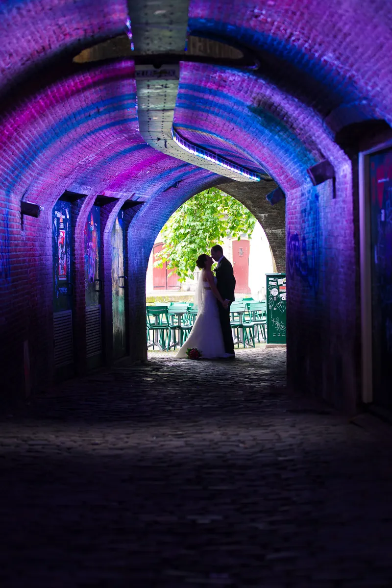 Tessa en Wessel als silhouet in een paars verlichte tunnel