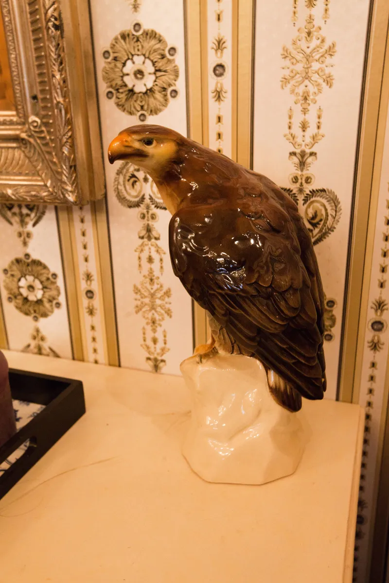 Een opgezette uil voor een wand met sierlijke ornamenten