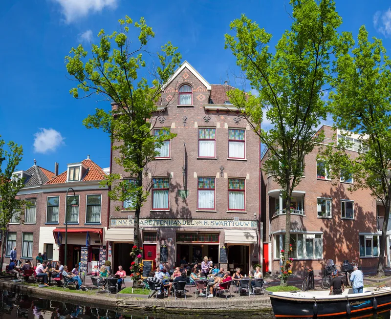 De gevel van het hotel tussen de bomen aan de gracht