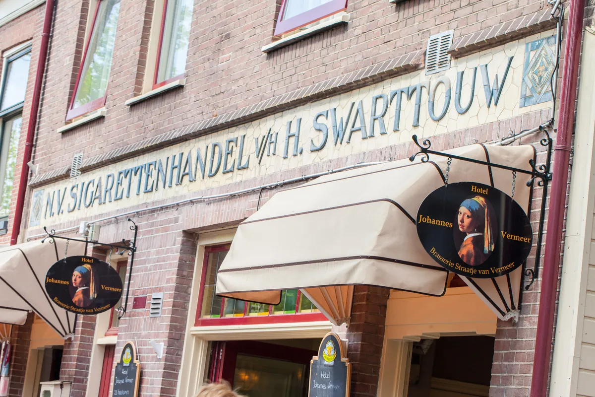 De oude gevelreclame ‘Sigarettenhandel v/h H. Swarttouw’ boven de luifel