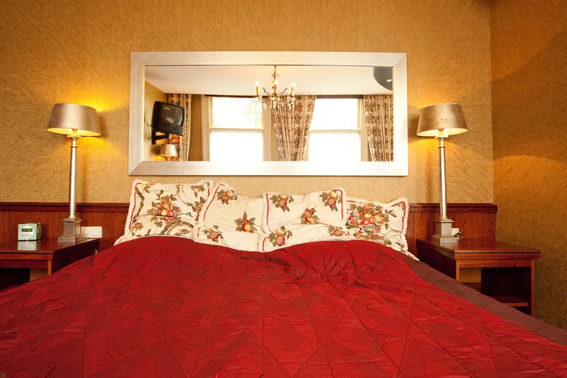 Een hotelkamer met een rode sprei