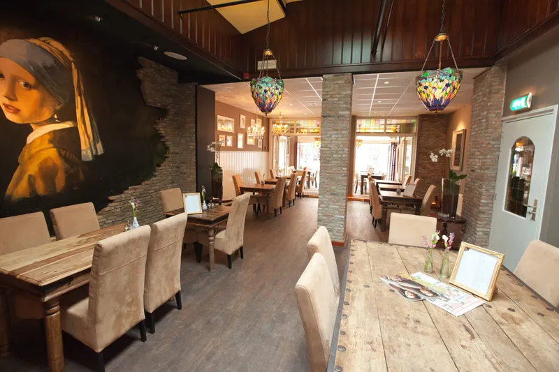 De lounge met de muurschildering van het Meisje met de parel