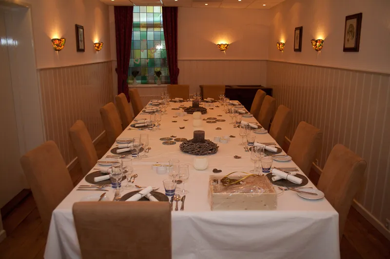De zaal met een lange, gedekte tafel