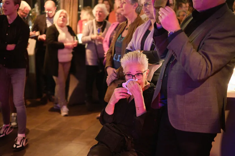 Een gast slaat haar hand voor haar mond