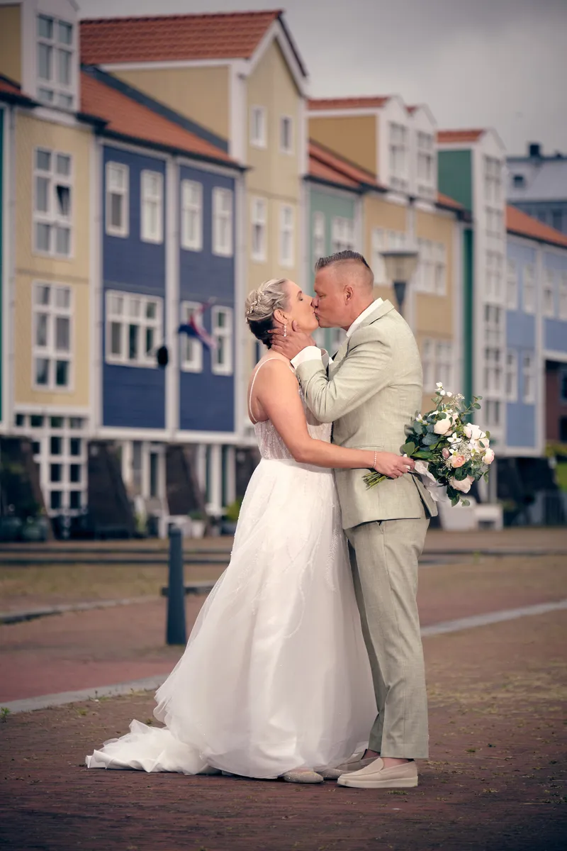 Marco en Tamara kussen voor de gekleurde huizen aan de haven