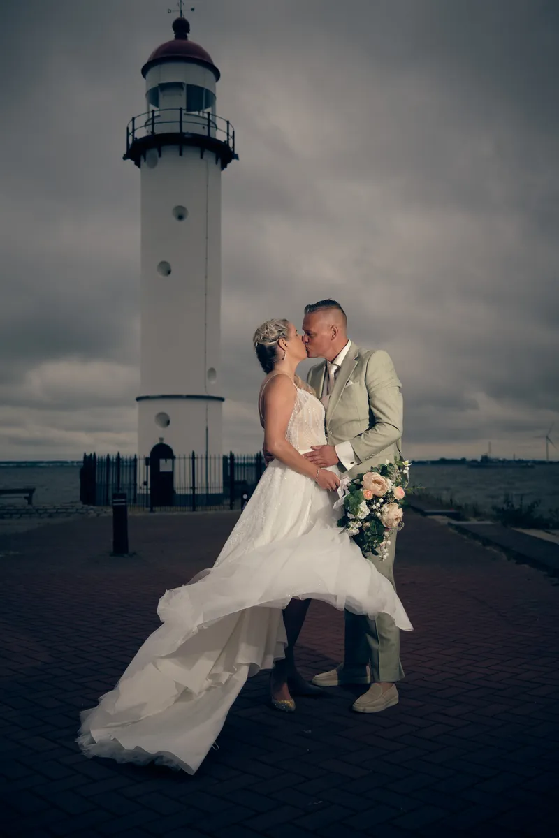 Marco en Tamara kussen bij de vuurtoren van Hellevoetsluis, de jurk waait op