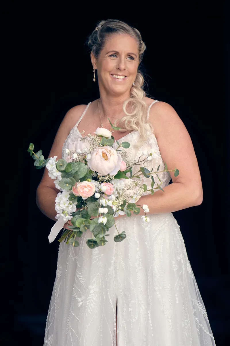 Tamara met haar boeket tegen een donkere achtergrond