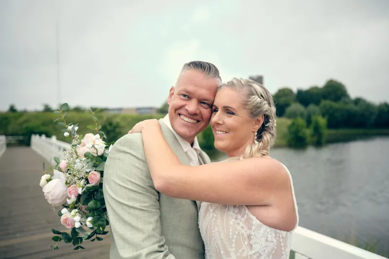 Marco en Tamara lachen op de brug, met het water erachter