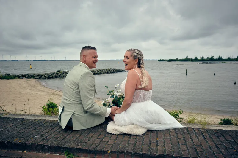 Marco en Tamara zitten op de kade aan het water