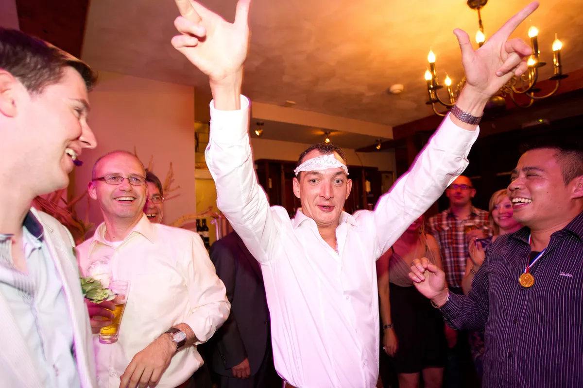 Gasten dansen met de armen omhoog