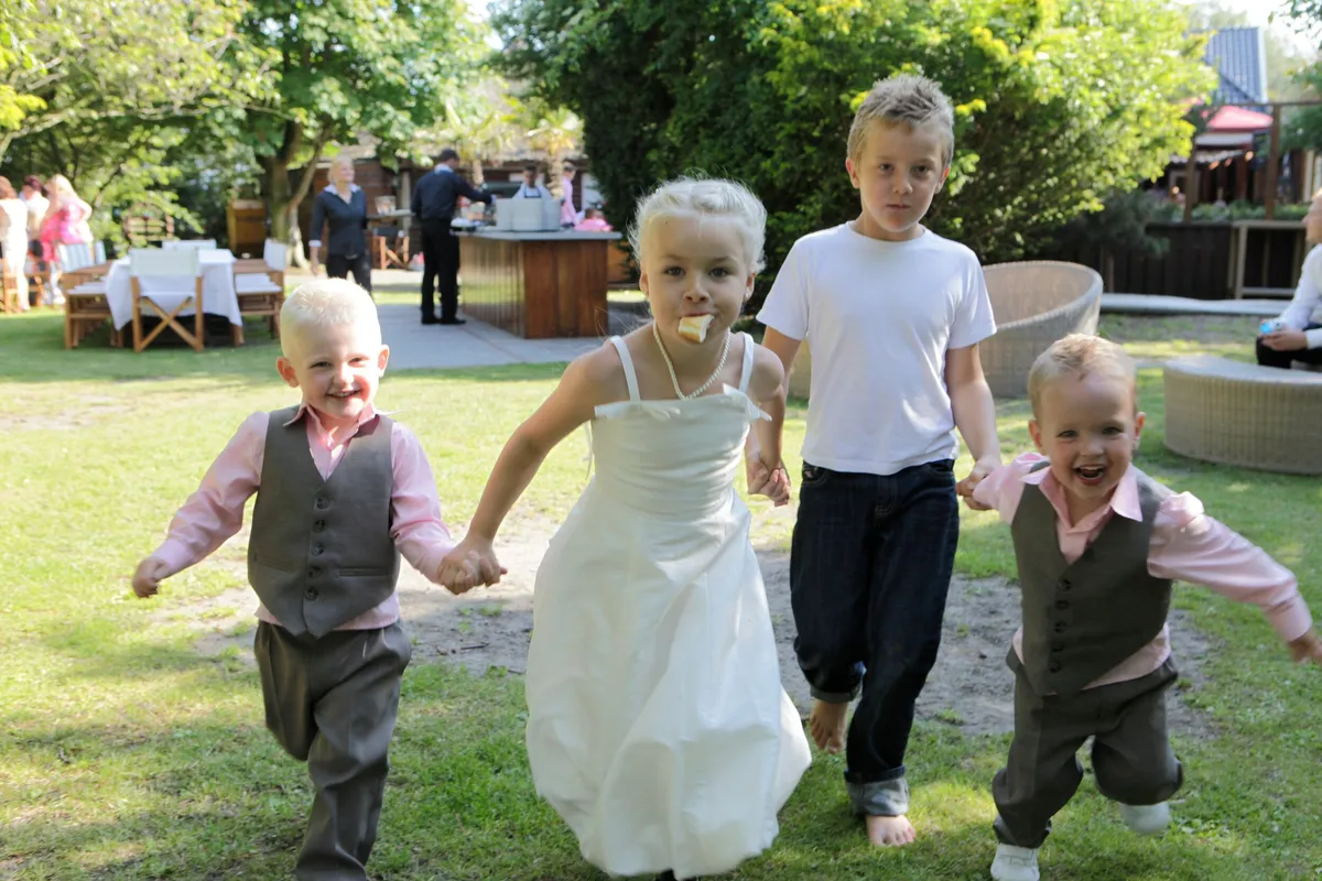 De kinderen rennen hand in hand over het gras