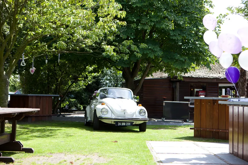 De witte Kever rijdt de tuin van De Viersprong op