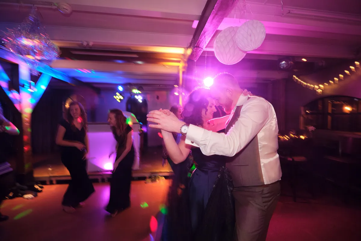 Maurice en Chantal kussen op de dansvloer in roze licht