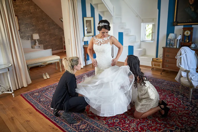 Frederike wordt in haar jurk geholpen op het tapijt in de suite