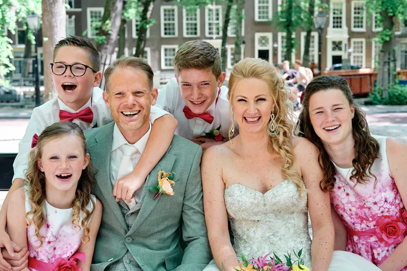 Neomi en Michael lachen met de kinderen op hun schouders