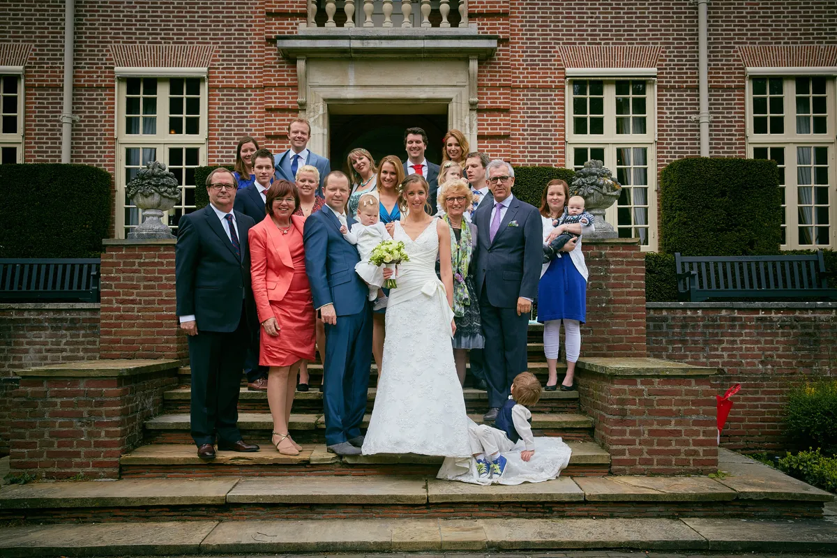 Groepsfoto met familie op de trap van het landhuis