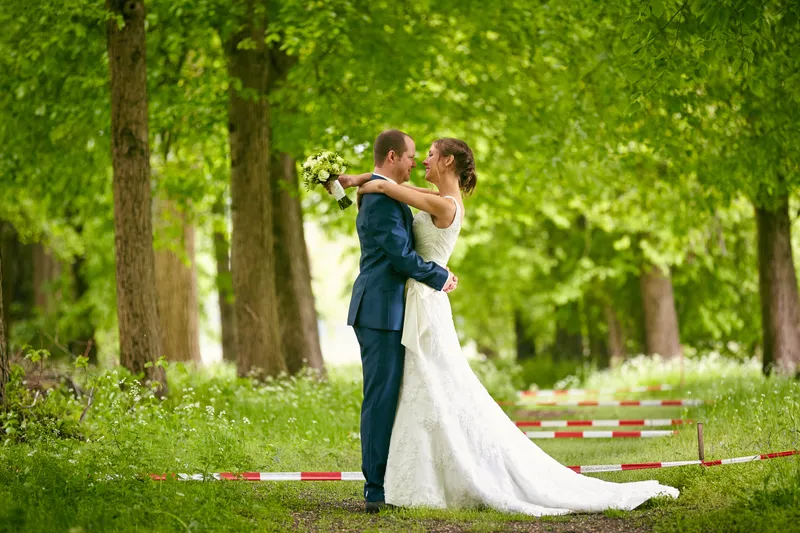 Elise en Maarten tussen de hoge bomen in het park