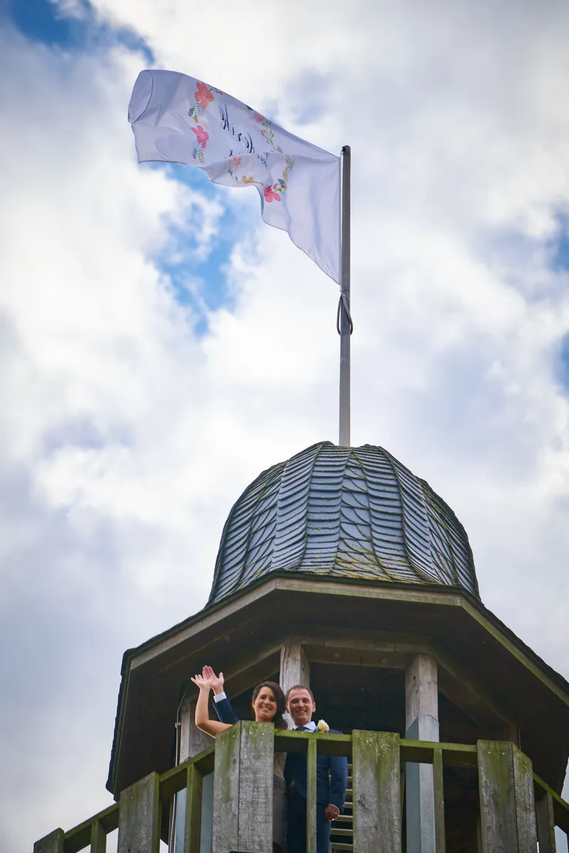 De eigen vlag wappert op de toren, Bart en Frederike zwaaien