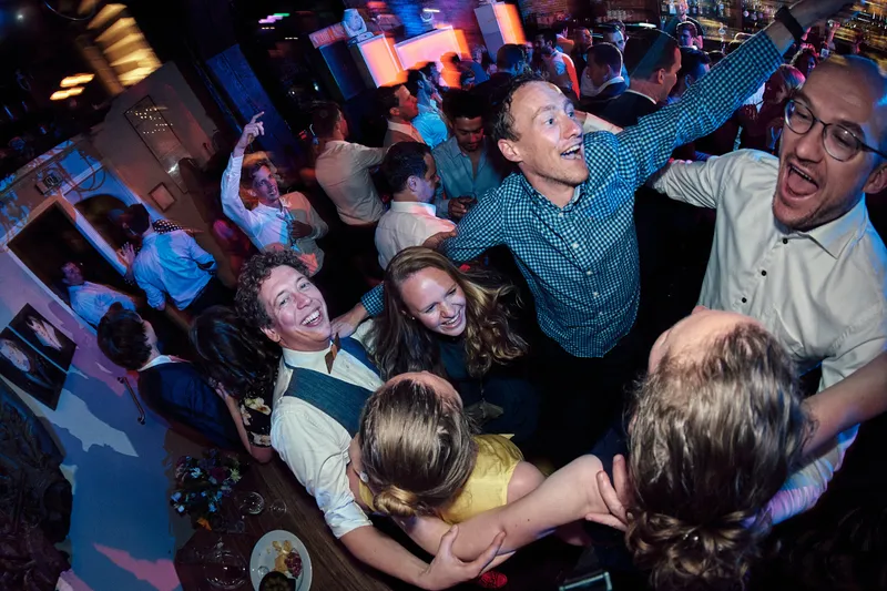 Gasten dansen in een kring op de dansvloer, door een fisheyelens