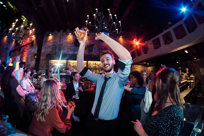 Een gast danst met zijn glas omhoog
