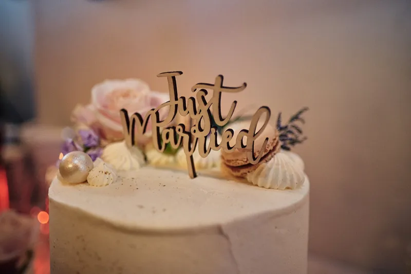 De bruidstaart met een gouden Just Married-topper