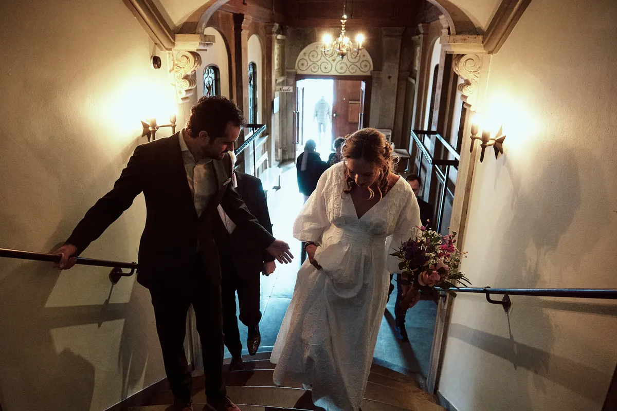 Anouk en Raphaël lopen de trap af in het warm verlichte stadhuis