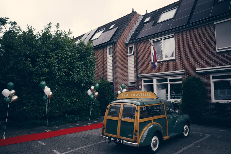 Een oldtimer met een rode loper voor de deur, bij Yvo en Marjolijn